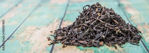 Loose dried darjeeling black tea leaves over wooden background
