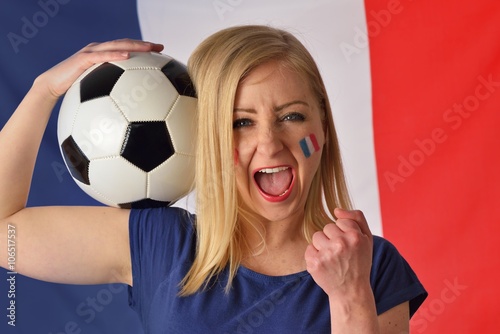 French soccer fan cheers football team in the national colors.
