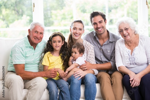 Portrait of smiling family with baby while sitting on sofa