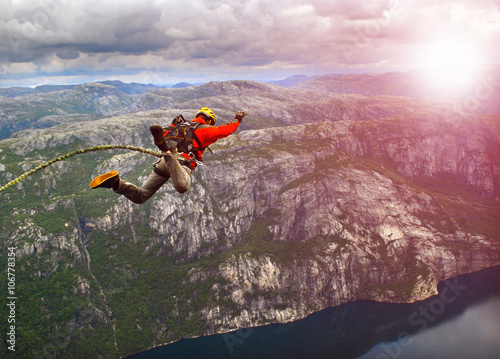 Young man jumping from a cliff into the abyss.