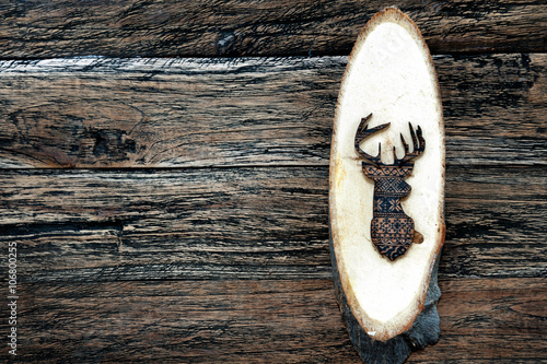 Wooden deer on wooden plank on wooden background
