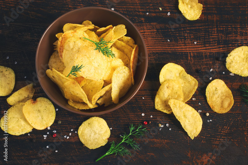 Crispy potato chips in a cup on a dark background, tinted