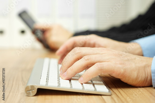 Businessman is typing on computer keyboard to contact clients w