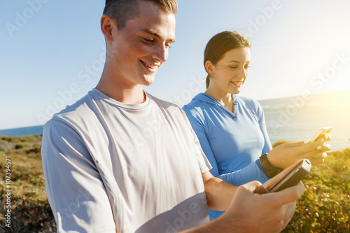 Young couple with smartphones outdoors