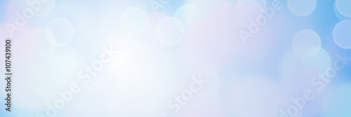 sunlit soft bokeh banner background in shades of blue 