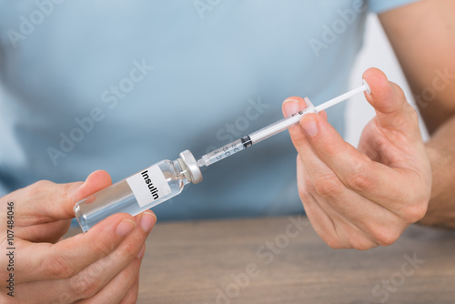 Man Holding Insulin And Syringe