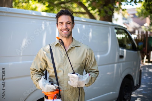 Smiling worker with pesticide sprayer