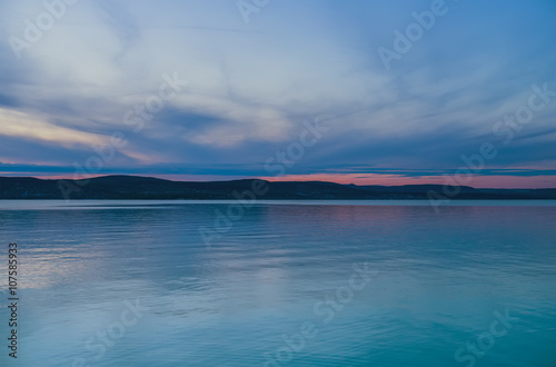 Evening view of the lake and mountains at sunset, blue hour. Balaton, Hungary.