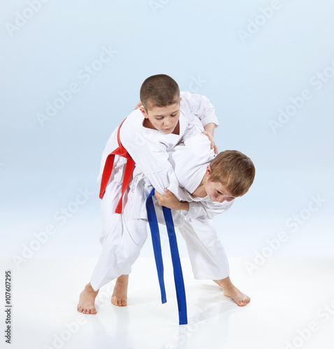 On a light background doing throws of judo athletes 