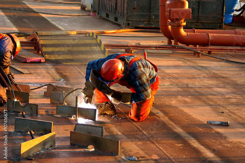 Shipyard welder during welding on the deck of the ship during the renovation