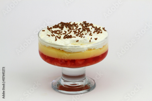 Traditional English strawberry trifle with fresh whipped cream on white background 