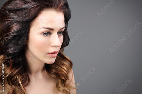 Stylizacja włosów, kobieca fryzura. Portret pięknej kobiety na czarnym tle.