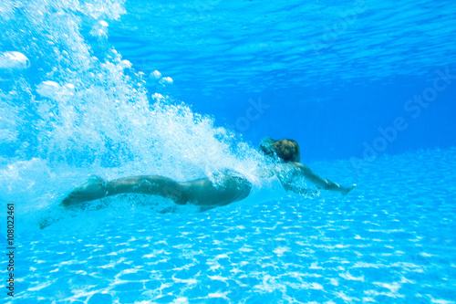 femme nageant dans une piscine sous l'eau