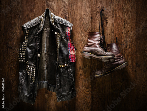 Punk jacket and boots hanging on a wall