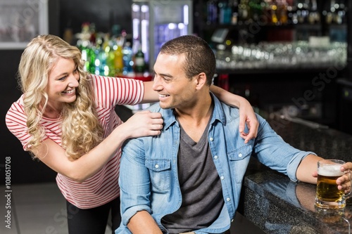 Smiling couple having a drink in a bar