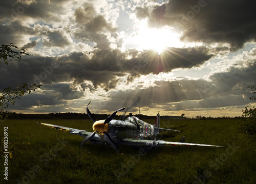 Crashed Spitfire in field with dramatic sunset WWII