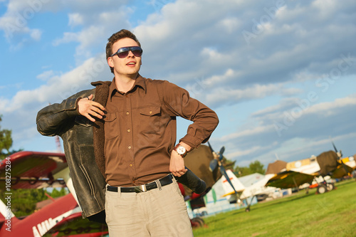 Outdoor portrait of attractive man at airport with vintage old propeller plane in Rybnik Gotartowice Poland