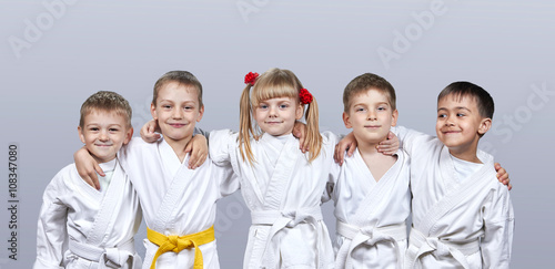 On a gray background little athletes in karategi