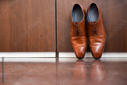 Brown leather shoes sitting on a wood floor