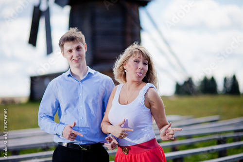 loving couple in the rural landscape. woman in a red dress and a man in a blue shirt