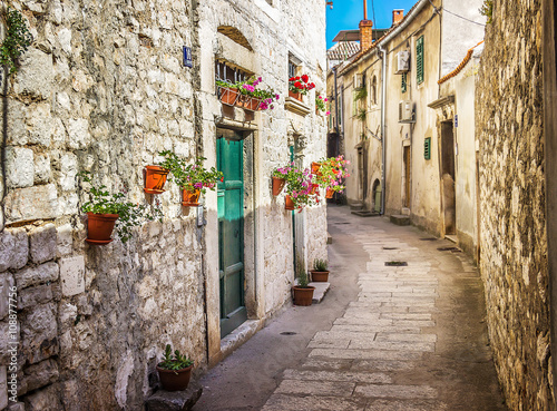 Narrow old street and yard in Sibenik city, Croatia, medieval zone