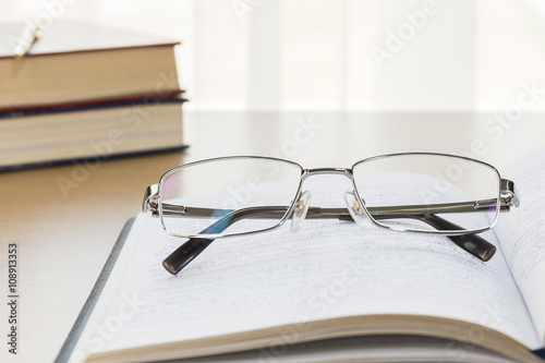 Eyeglasses put on notebook on wood table