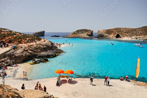 BLUE LAGOON, COMINO, MALTA - APRIL 13, 2016. People enjoy blue lagoon with crystal clear blue water.
