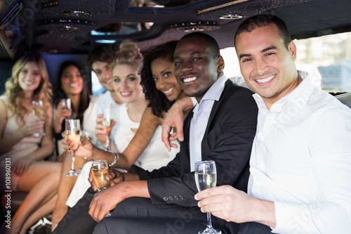 Well dressed people drinking champagne in a limousine