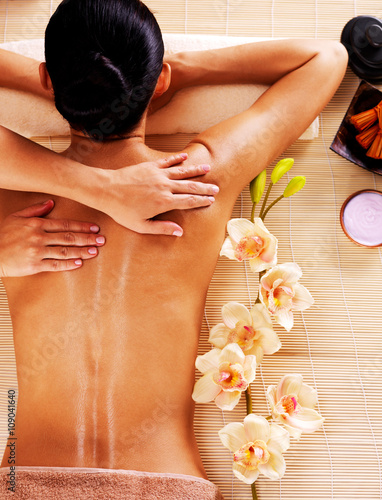 Adult woman in spa salon having body massage.