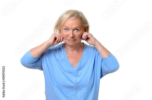 Elderly woman pulling at the skin on her jowls