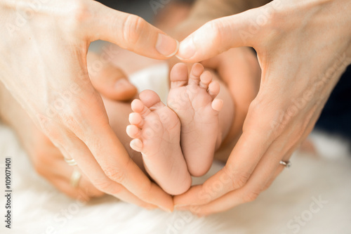 Hand formt ein Herz um Baby Füße