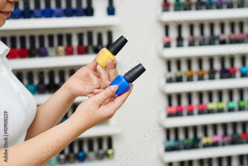 Manicurist offering pink or blue nail polish to the client