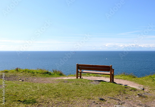 Empty bench near the sea staying lonely on the grass