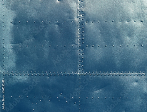Abstract blue painted metal background. Texture with seams and rivets.