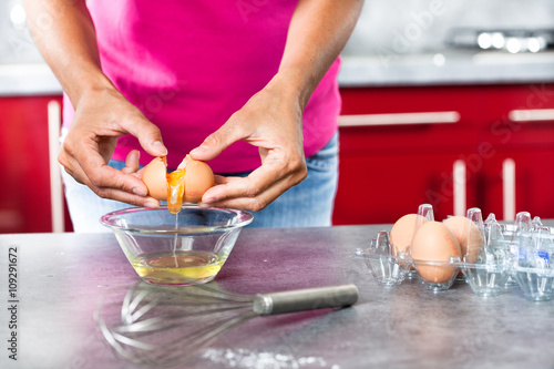 femme qui sépare les jaunes des blancs d'oeufs 