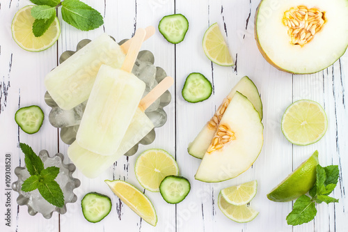 Refreshing mexican style ice pops - cucumber, lime, honeydew margarita paletas - popsicles. Top view, overhead. Cinco de Mayo recipe