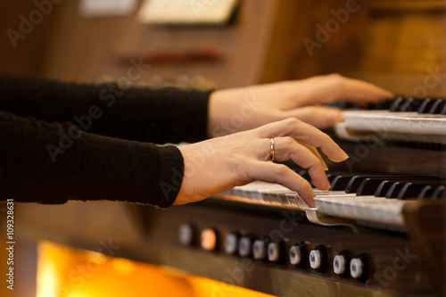 Hands of a woman playing the organ closeup