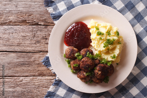 fried meatballs, lingonberry sauce with potato garnish. Horizontal top view 