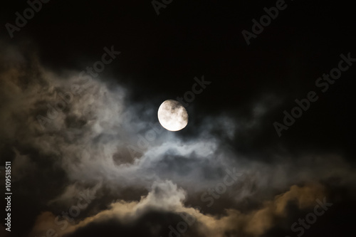 moon surrounded by dark clouds at night