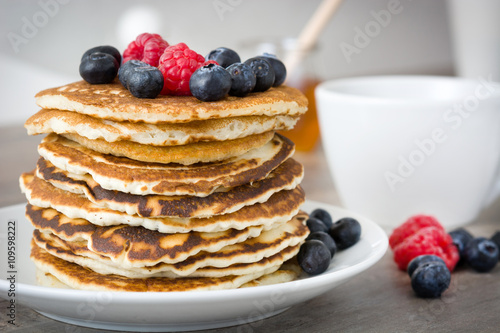 Sweet pancakes with blueberries and raspberries pon rustic wood