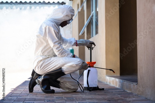 Side view of a man doing pest control