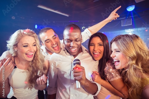  Happy friends singing at the karaoke