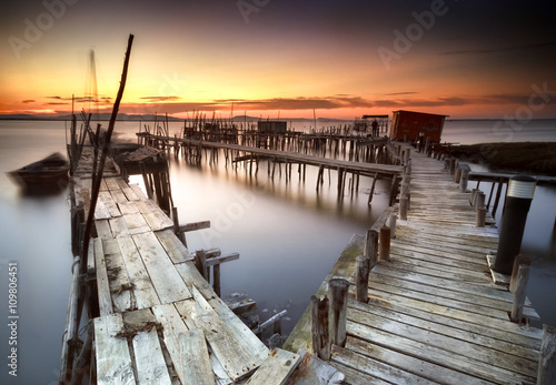Ancient fishing pier with warm and beautiful sunset