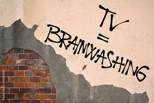Handwritten graffiti TV = Brainwashing sprayed on the wall, anarchist aesthetics. Appeal to avoid watching and listening media of mainstream and popular mass culture