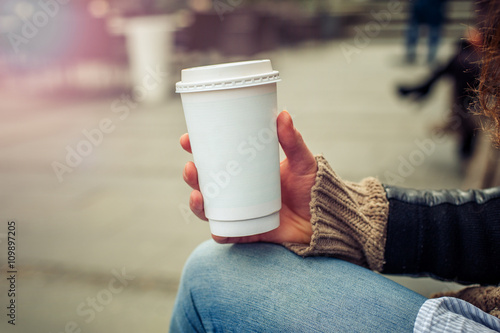 Coffee to go / Woman drinking coffe on the street. Close up