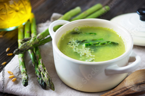 Creamy asparagus soup on wooden background