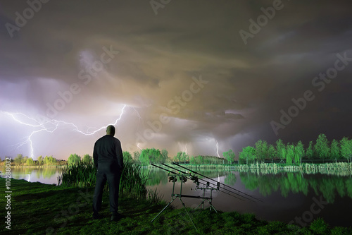 The storm is coming. Man standing in a storm. Man with cloud over his head. Night Fishing in a storm