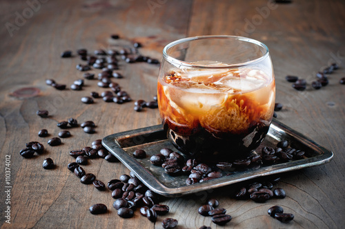 Kahlua liqueur with cream in glasses with coffee beans on a wooden background, selective focus