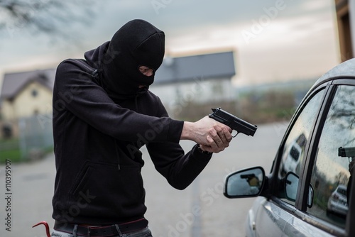 car thief pointing a gun at the driver