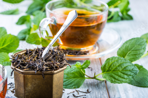 Tea. Mint Tea. Herbal tea. Mint leaf. Mint leaves. Tea in a glass cup, mint leaves, dried tea, sliced lime. herbs tea and mint leaves on a slate plate in a restaurant or teahouse tea room.